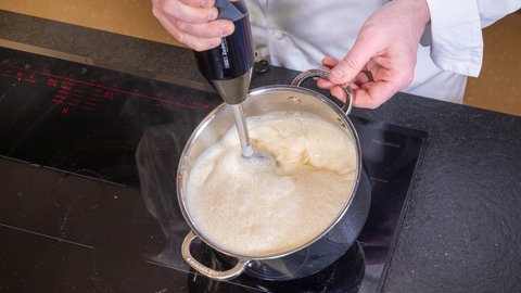 Eine helle Sauce wird für den Kabeljau aus dem Ofen mit einem Pürierstab durchgemixt.