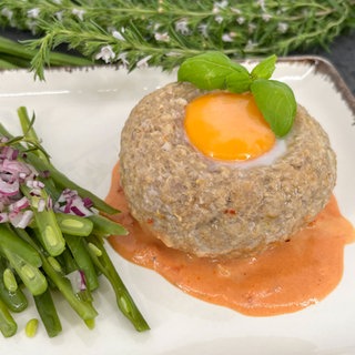 Ei auf Fleischpflanzerl in Tomaten-Rahm-Sauce und Bohnensalat