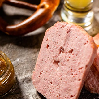 Fleischkäse mit süßem Senf, Brezeln und Bier