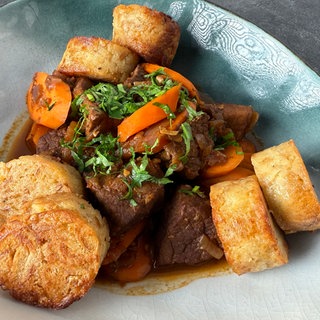 Gulasch mit Karotten, roten Zwiebeln und Semmelknödeln