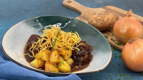 Zwiebelrostbraten mit Kartoffelstroh und Bratkartoffeln