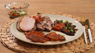 Schweinerücken mit Barbecuesoße, Secreto-Steak-Streifen, Smashed Potatoes, karamellisierte Möhren und Tomaten-Gurken-Minz-Brunoise auf einem teller