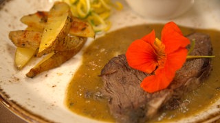 Braten vom Weideochsen mit Kartoffel-Wedges, Wildkräuterpüree und Zucchini-Spaghetti