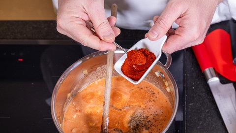 Lecker und unkompliziert an Silvester – Rezept für Würstchengulasch: Paprikapulver wird hinzugefügt.