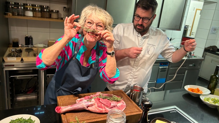 Moderatorin Petra Klein und Sternekoch Andreas Widmann beim Kochen.