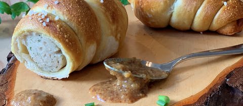Eine Weißwurst im Brezelteigmantel.