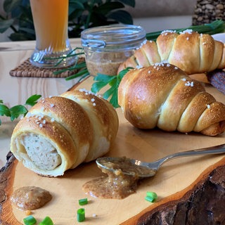 Eine Weißwurst im Brezelteigmantel.