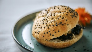 ein Brötchen mit pulled pork auf einem Teller