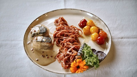 Ein Teller mit Damwildrückensteaks und Beilagen auf einem Teller