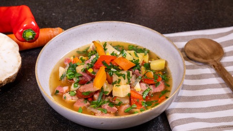 Ein Teller mit leckerem Eintopf und Mettwurst.