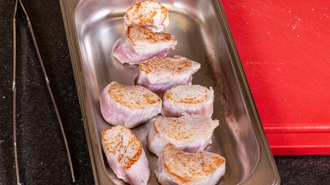 Schweinefilet mit Birnen-Maronen-Gemüse: Die angebratenen Schweinemedaillons liegen in einer Form.