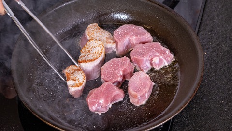 Schweinefilet mit Birnen-Maronen-Gemüse: In einer Pfanne werden die Schweinemedaillons fürs Weihnschtsmenü angebraten.
