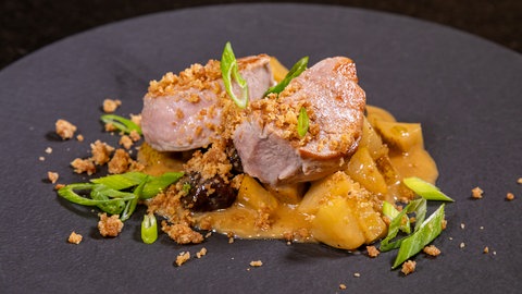 Medaillons vom Schweinefilet mit Birnen-Maronen-Gemüse: Der Hauptgang vom Weihnachtsmenü zum Servieren auf einem Teller angerichtet.