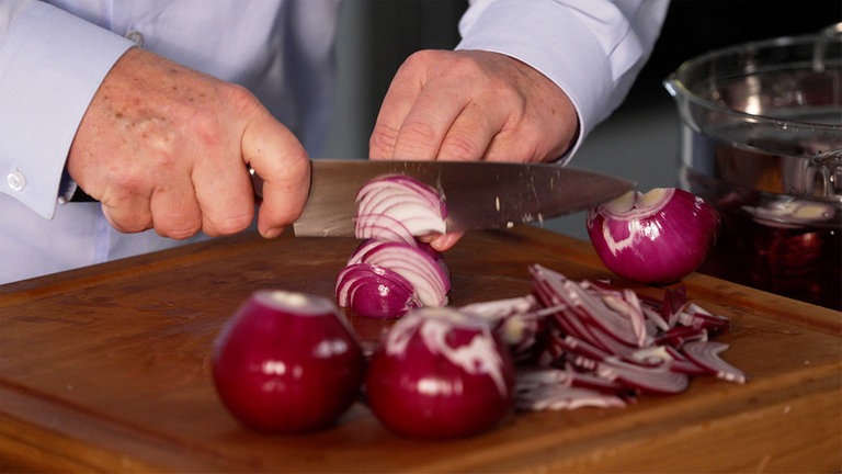 Johann Lafer bevorzugt ein scharfes Messer ohne Säge, damit der Zwiebelsaft in den Spalten bleibt.
