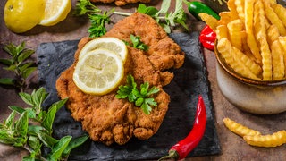 Schnitzel auf einem Brett mit Pommes