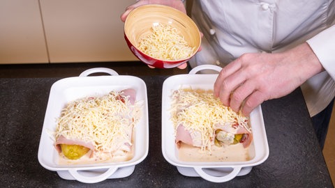 Gratin-Käse wird über den Chicorée gestreut, bevor das Gericht in den Ofen kommt.