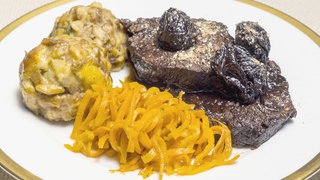 Schmorbraten mit Brezelknödel Karotten-Spaghetti auf einem Teller