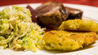 Gänsebrust mit Maronen-Wirsing und Kartoffeltalern auf einem Teller