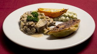 Zwiebelfleisch mit Krautkrapfen auf einem Teller