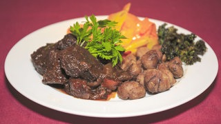 Rindergulasch mit „Keschdegemies“ und Karotten auf einem Teller