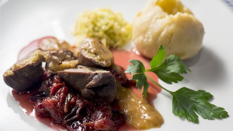 Wildschweinroulade mit Kartoffelkloß auf einem Teller