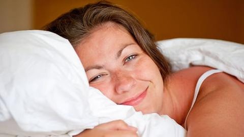 Eine junge Frau liegt auf einem Kopfkissen