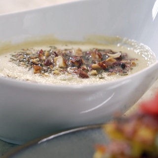 Auf dem Bild sieht man eine kalte Melonen-Suppe. Das Fruchtfleisch mit geschälter Gurke sowie dem Abrieb und dem Saft einer Limette in den Mixer geben. Dann kommen Frischkäse, Salz und Pfeffer hinzu. Weiter glatt pürieren. Jetzt muss die Melonensuppe nur noch gut gekühlt werden.