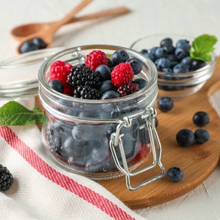 Heidelbeeren, Brombeeren und Himberen in einem Glas. So gesund sind Beeren.