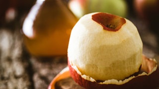 Apfel und Flasche Apfelessig auf Holz