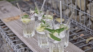 Gläser mit Holunderblütenlimonade auf einem Brett