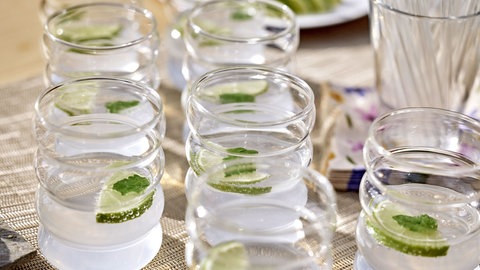 mehrere Gläser mit Limettenwasser und einer Limettenscheibe