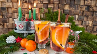 Gläser mit Punsch, Orangen und weihnachtlichen Gewürzen