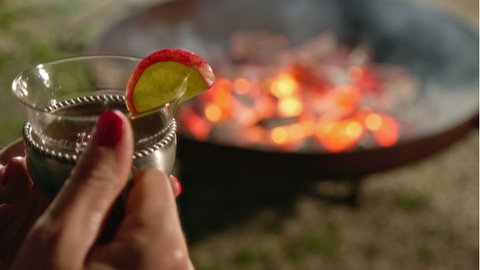 Ein Glas Punsch „Heißer Apfel“ vor einem brennenden Feuerschale