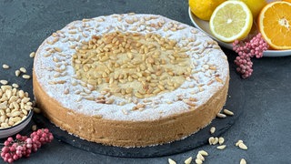 Gedeckter Mürbeteigkuchen mit Vanillecreme und Pinienkernen