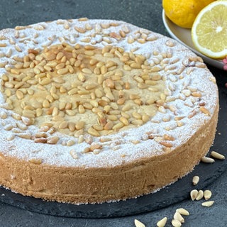 Gedeckter Mürbeteigkuchen mit Vanillecreme und Pinienkernen
