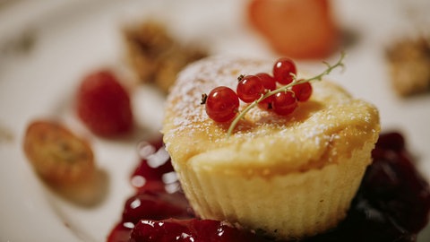 Käseküchlein mit Zwetschgenkompott und Walnusskrokant auf einem Teller