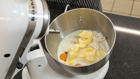 SWR4 Konditor Joachim Habiger zerbröselt die frische Hefe und gibt die restlichen Zutaten für den Teig dazu. Dann wird das Rührgerät angeworfen.