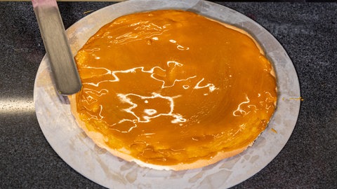 Helles Karamell auf einen Biskuitboden streichen.