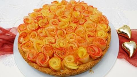 runder Kuchen mit Äpfeln, wie Rosenblätter darauf drapiert für Muttertag