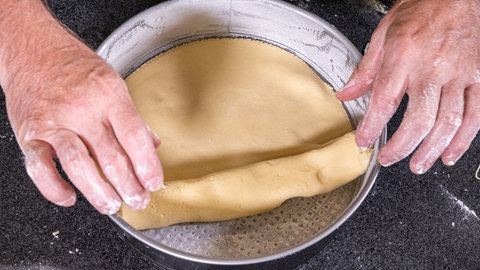 Rezept: Gedeckter Apfelkuchen mit Mürbeteig, der in der Springform ausgelegt wird.