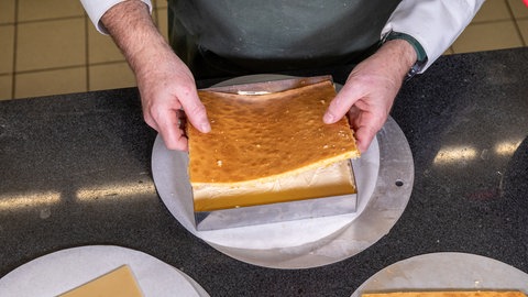 Für Petit Fours den Boden mit Buttercreme einstreichen und den nächsten Boden drüber legen