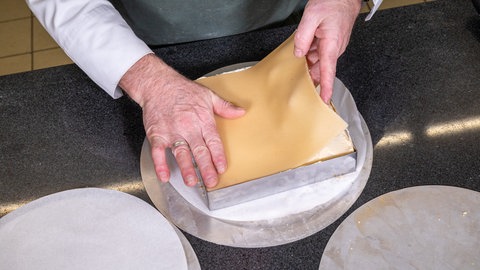Für die Petit Fours wird auf den letzten Boden ein Deckel aus Marzipan gelegt und angedrückt.