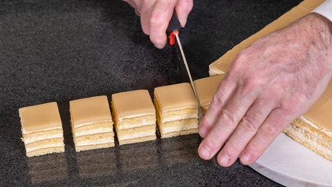 Mit einem Messer die Petit Four in gleichgroße Quadrate schneiden.