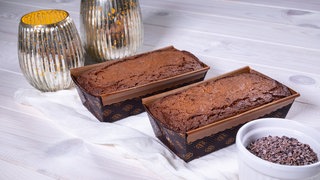 Zwei Schokokuchen stehen auf einem gedeckten Tisch