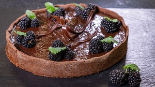 Saftiger Schokokuchen garniert mit Brombeeren, Minze und Schokosplittern: Bei diesem Rezept trifft Sommerfrische auf Schoko-Genuss. 