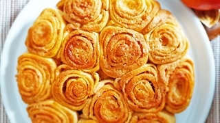 Apfel-Zimtschnecken in einer Runde wie eine Torte auf einer Platte angeordnet