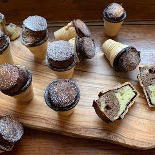 Auf einem Tisch liegen viele kleine Kuchen im Waffelbecher. Das ideale Rezept, um schnell kleine Marmorkuchen für die nächste Party, den Kindergeburtstag oder als Snack für die Schule zu backen.
