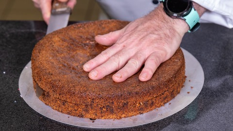 Der saftige und glutenfreie Nussboden wird in zwei Teile geschnitten.