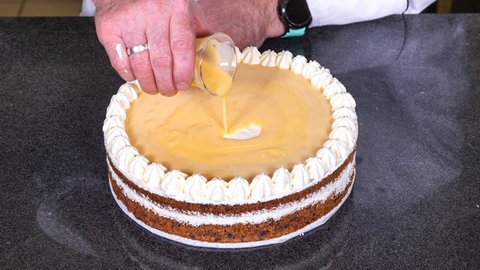 Frischer Eierlikör wird auf die Eierlikörtorte gegossen.