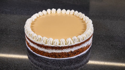 Eine Eierlikörtorte, die glutenfrei und schön saftig ist, steht auf einer Arbeitsplatte.